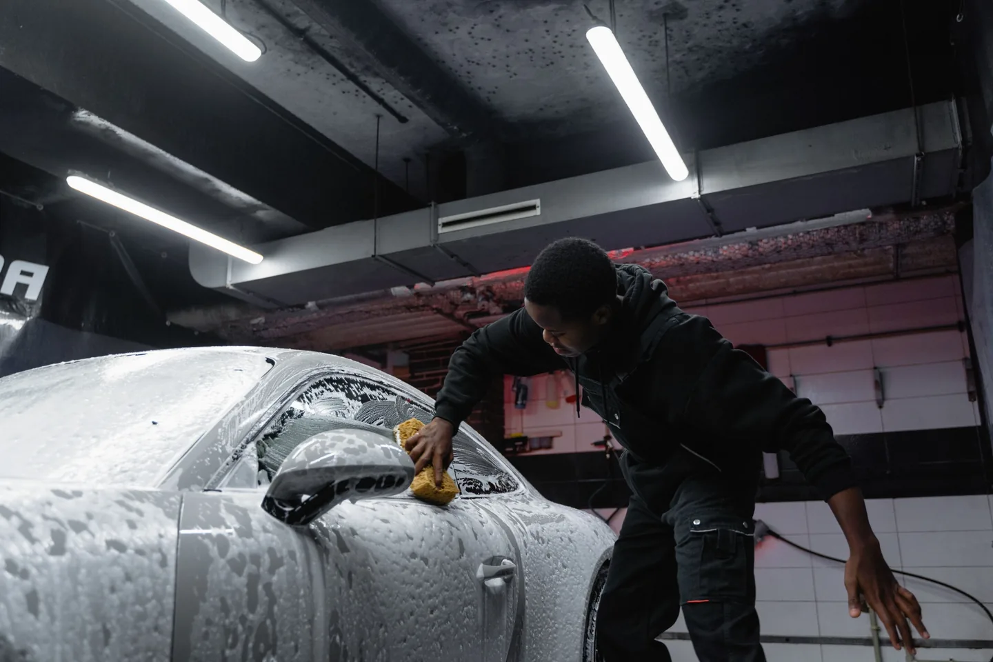 An automotive detailer caring for a customer's vehicle in his workshop